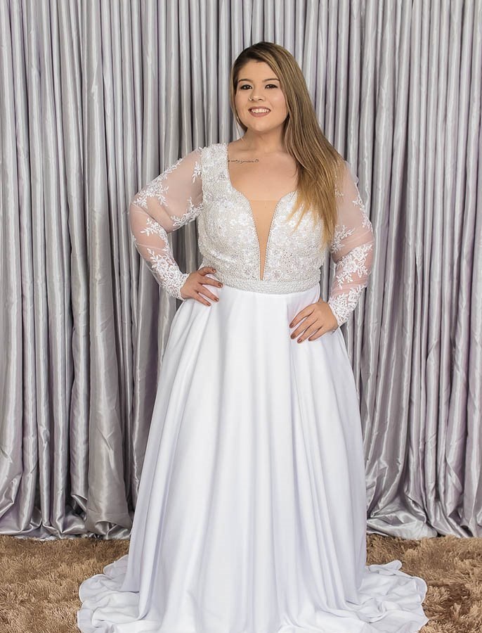 Noiva Plus Size sorridente de vestido com mangas de renda e saia ampla
